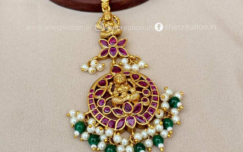 antique maang tikka with a lavish pendant made of pink and green pearls
